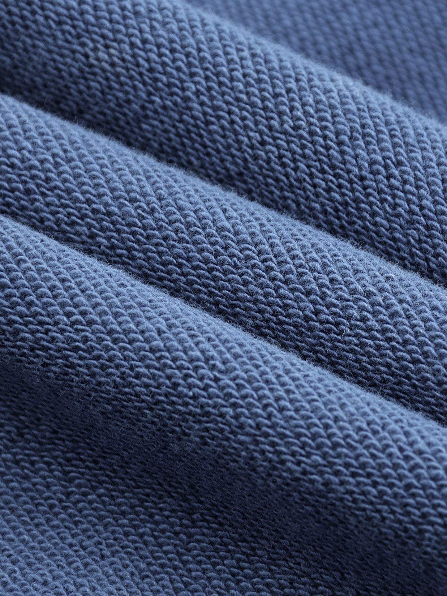 Macro close-up of blue Existential snow wash hoodie terry knit fabric texture