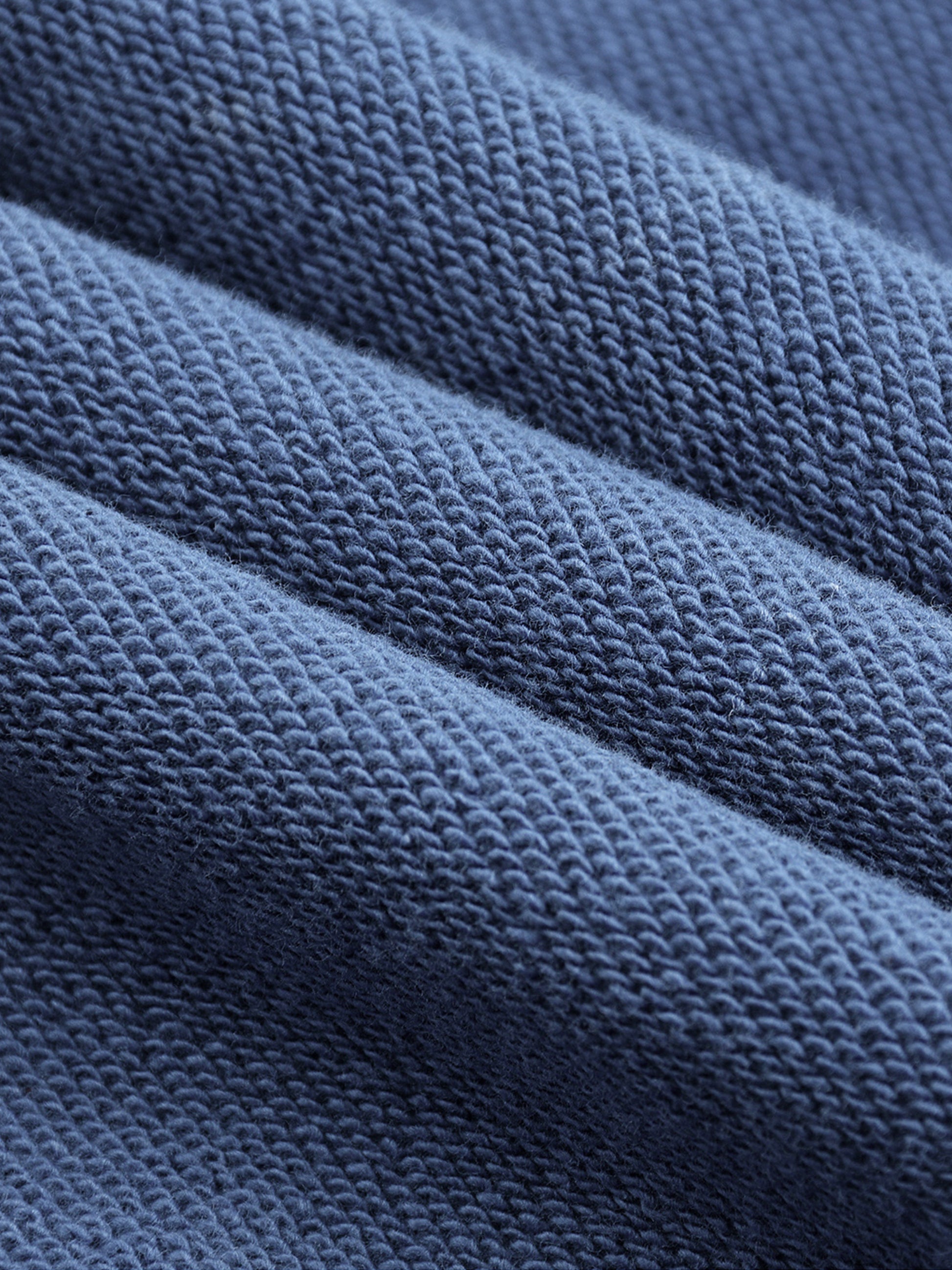 Macro close-up of blue Existential snow wash hoodie terry knit fabric texture