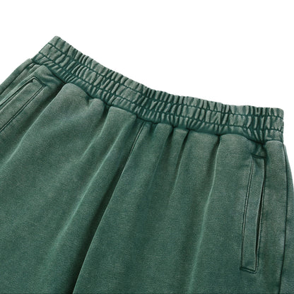 Green sweatpants with an elastic waistband on a white background