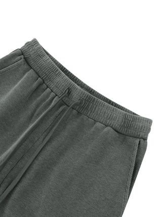 Front waistband detail of the gray Existential waffle knit sweatpants, elastic waist with flat drawstring, on a white studio background