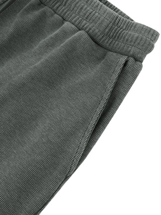 Side pocket detail of the gray Existential waffle knit sweatpants, showing the topstitched pocket opening and textured waffle fabric