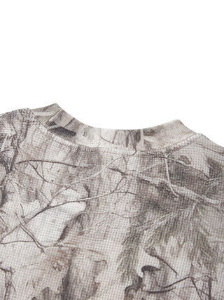 Neckline detail of the PsySquatch tree camo waffle long sleeve, ribbed crew collar with the snow tree camo print carrying across the shoulder