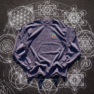 Front of the Mystic Myco acid wash oversized long sleeve tee in Purple Haze, styled on dark asphalt covered in white chalk sacred geometry, with the Phantasmagorical logo on the left chest.