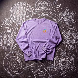 Front of the Mystic Myco acid wash oversized long sleeve tee in Purple, styled on dark asphalt covered in white chalk sacred geometry, with the Phantasmagorical logo on the left chest.