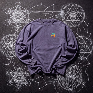 Front of the Ouroboros Gate acid wash oversized long sleeve tee in Purple Haze, styled on dark asphalt covered in white chalk sacred geometry, with the Phantasmagorical logo on the left chest.