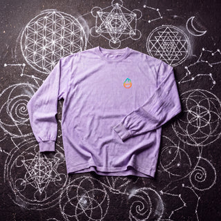 Front of the Ouroboros Gate acid wash oversized long sleeve tee in Purple, styled on dark asphalt covered in white chalk sacred geometry, with the Phantasmagorical logo on the left chest.