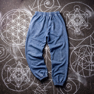 Back view of the Paradigm heavyweight snow wash joggers in washed Royal Blue on chalk sacred geometry asphalt, showing the plain back, gathered elastic waistband and ribbed ankle cuffs.