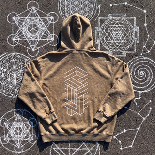 Back of the Paradigm snow wash hand-frayed heavyweight hoodie in brown, laid flat on dark asphalt covered in white chalk sacred geometry, printed with a tall white impossible-geometry column of interlocking beams.
