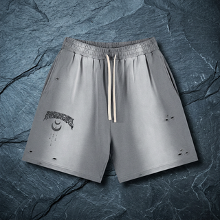 Gray sun fade Phantasm heavyweight shorts on dark slate, with cream drawstring, a tonal Phantasmagorical wordmark and crescent moon graphic on one leg.