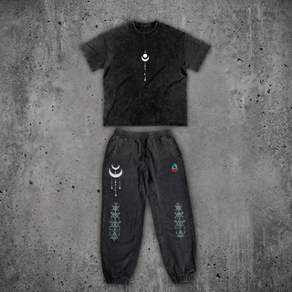 Existential Snow Wash Set by Phantasmagorical — snow-wash black 250 GSM heavyweight oversized tee with a crescent moon and star talisman print, shown above the matching 420 GSM snow wash heavyweight joggers with crescent moon and sacred-geometry line art down the leg, laid flat on concrete.