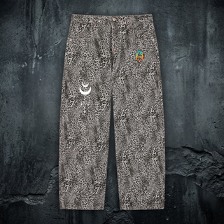 Gray and tan leopard print Existential wide leg jeans laid flat on dark concrete, with a small white crescent moon graphic on one leg and the colorful Phantasmagorical logo on the other.