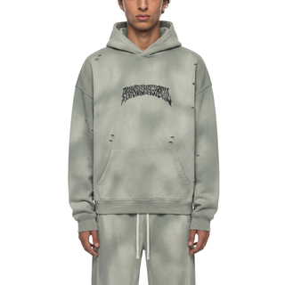 Model wearing the Light Gray Enigma sunfade frayed fleece hoodie with the hood down, oversized boxy fit, kangaroo pocket, small fray openings, and the arched Phantasmagorical wordmark on the chest, paired with matching sweatpants