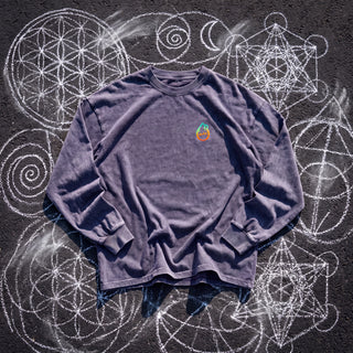 Front of the PsySquatch acid wash oversized long sleeve tee in Purple Haze, styled on dark asphalt covered in white chalk sacred geometry, with the Phantasmagorical logo on the left chest.