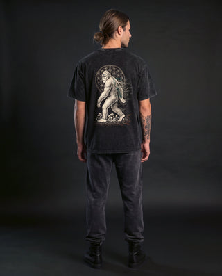 Model wearing the PsySquatch snow wash relaxed fit tee in Black, back view, showing the full back artwork.