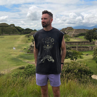 Man wearing Dimensional Drift snow wash tank at ancient ruins with purple shorts