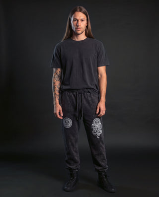 Model wearing the Spirit Molecule snow wash drawstring cotton pants in Black, front view, showing the full leg artwork.